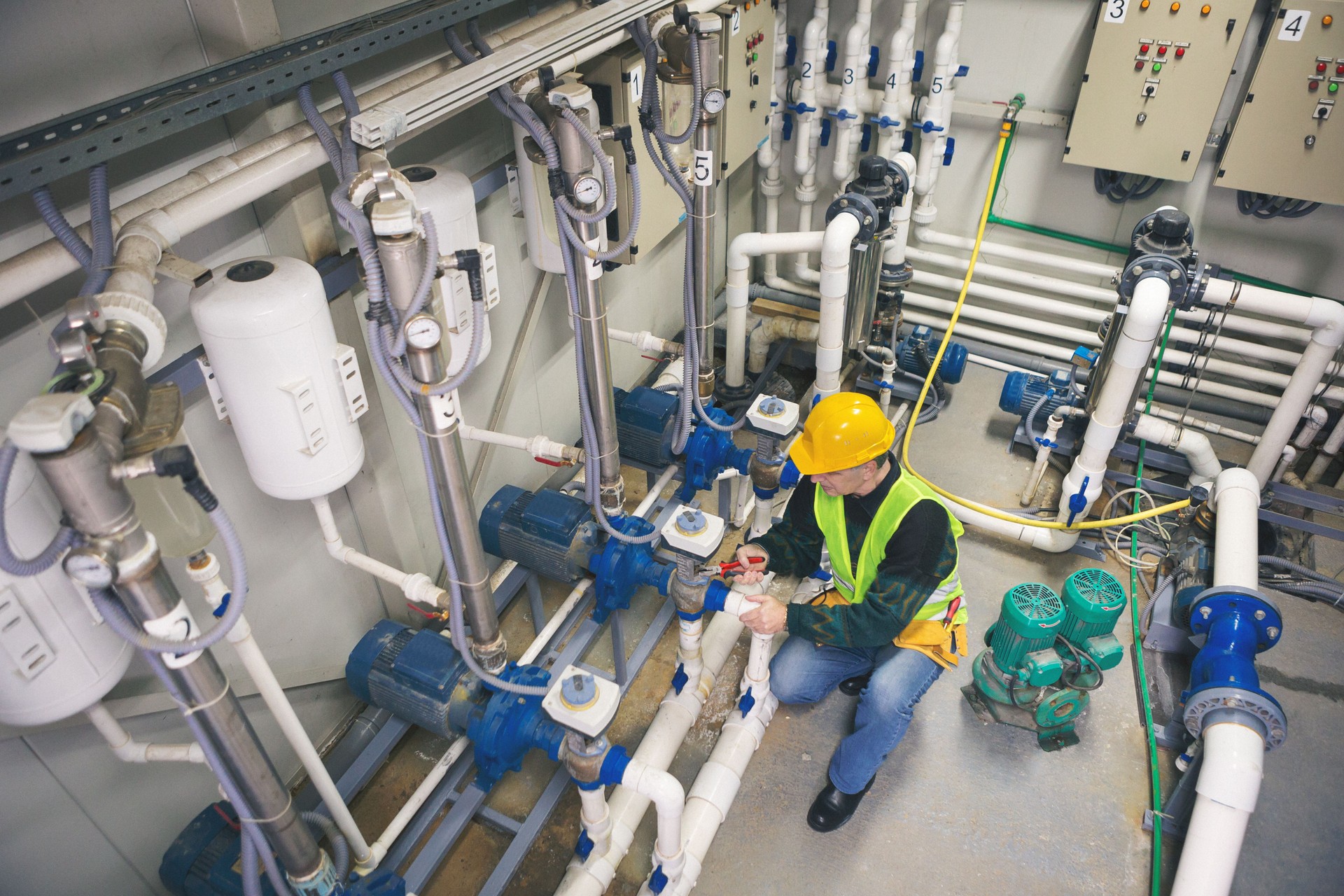 Technician repairing pipes in boiler room